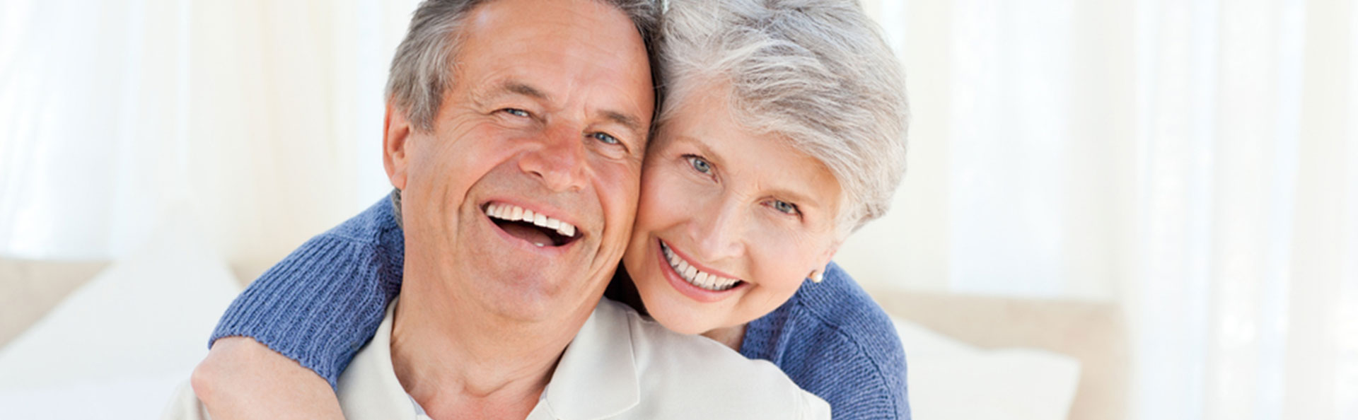 Senior couple smiling with partials (traditional, flexible, and implant retained and supported partials)
